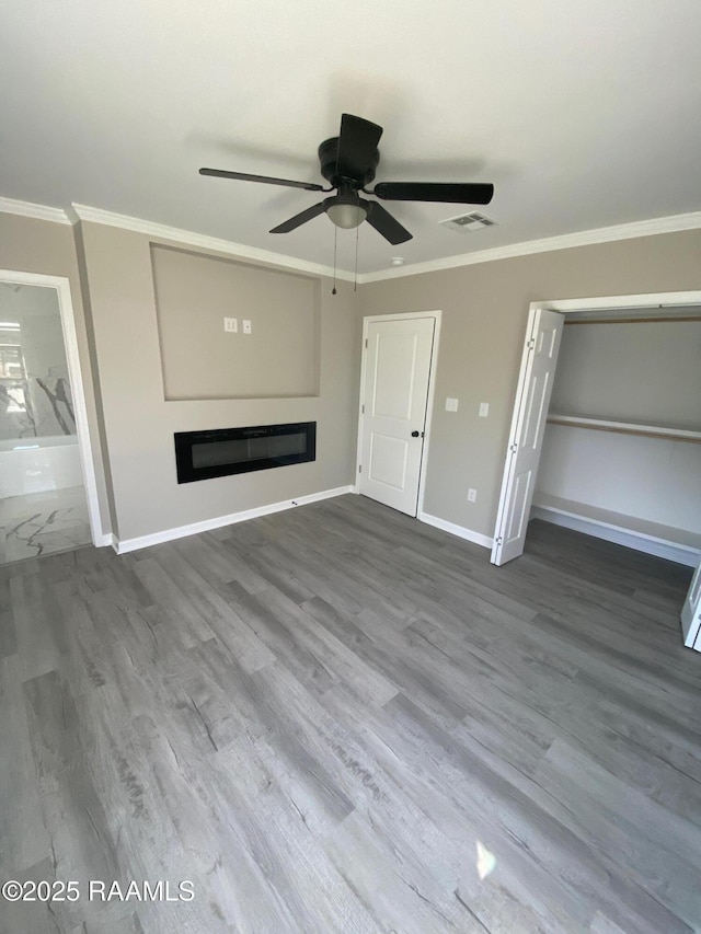 unfurnished living room featuring visible vents, wood finished floors, crown molding, baseboards, and ceiling fan