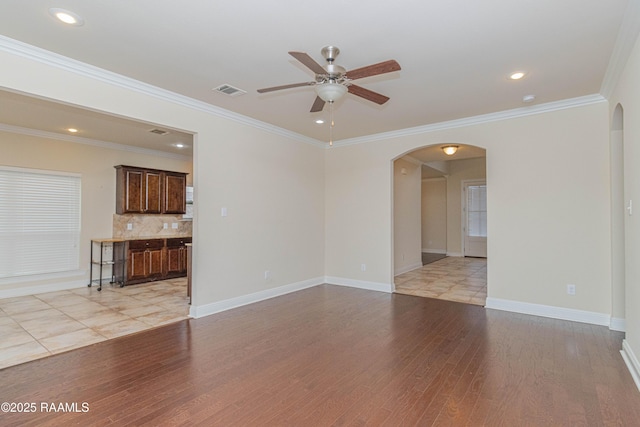 unfurnished living room with crown molding, ceiling fan, and light hardwood / wood-style flooring