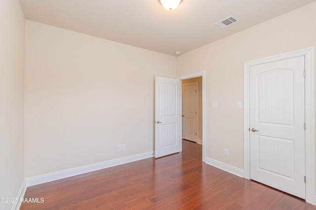 unfurnished room with dark wood-type flooring