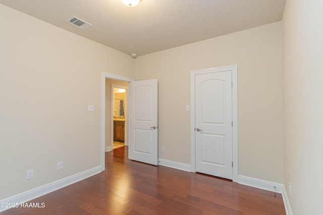 unfurnished bedroom with dark hardwood / wood-style flooring