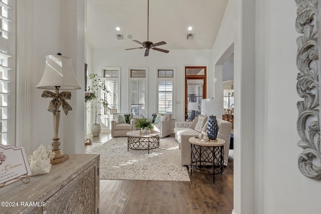 living room featuring dark hardwood / wood-style floors, vaulted ceiling, and ceiling fan