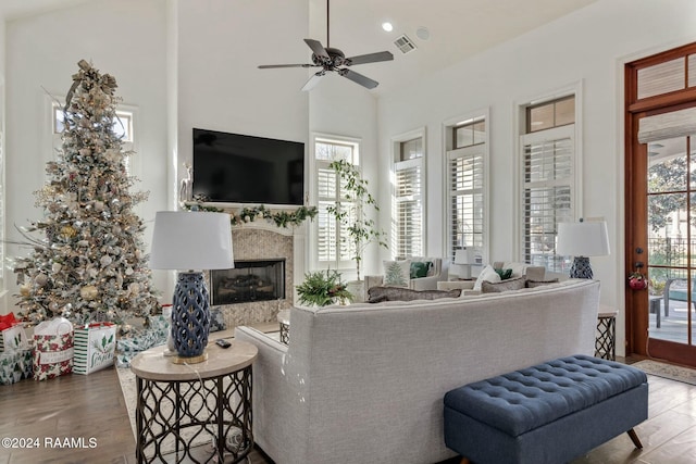 living room featuring a fireplace, hardwood / wood-style flooring, high vaulted ceiling, and ceiling fan