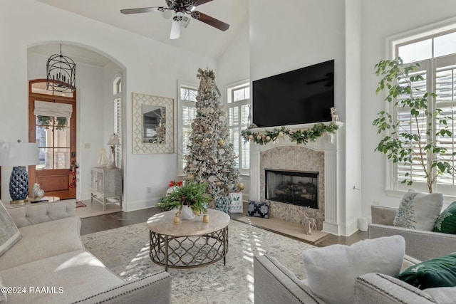 living room with ceiling fan, a fireplace, and high vaulted ceiling