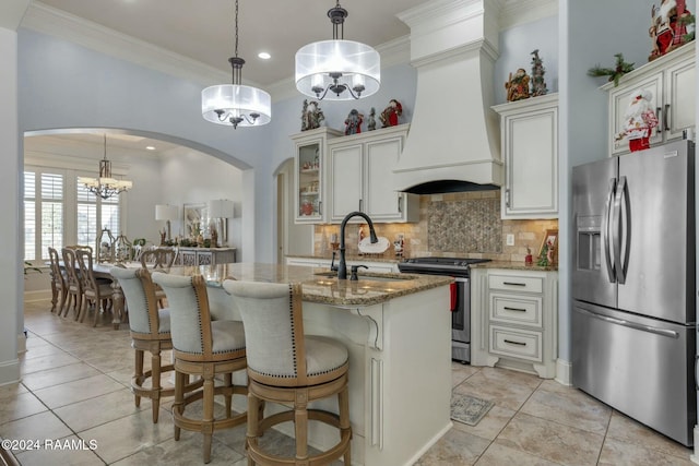 kitchen with white cabinets, dark stone counters, custom range hood, and appliances with stainless steel finishes