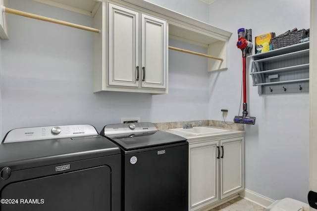 laundry room featuring washer and clothes dryer, cabinets, ornamental molding, and sink