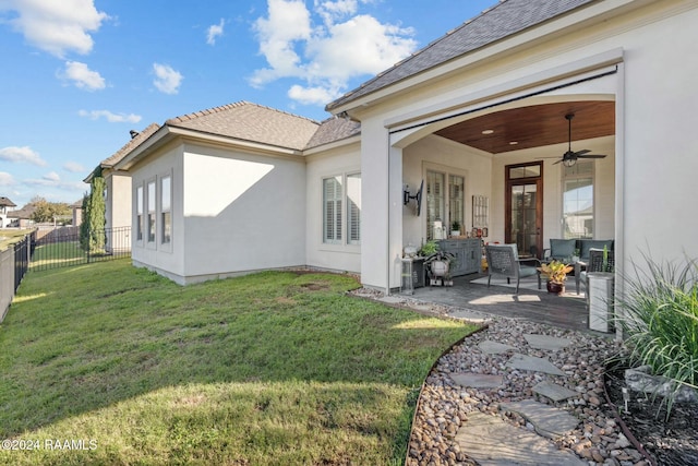 back of property with a lawn, ceiling fan, and a patio