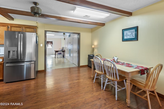 dining room featuring beam ceiling, a textured ceiling, dark hardwood / wood-style floors, and ceiling fan