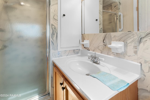 bathroom featuring vanity and an enclosed shower