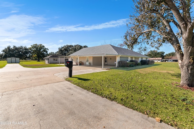 ranch-style home with an outdoor structure and a front lawn