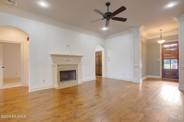 unfurnished living room with a premium fireplace, ceiling fan, light hardwood / wood-style floors, and ornamental molding