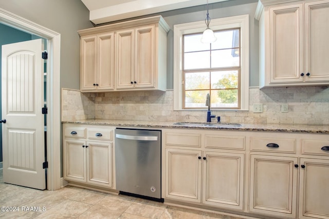 kitchen with hanging light fixtures, sink, stainless steel dishwasher, decorative backsplash, and cream cabinetry