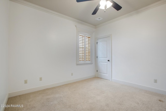 empty room featuring light carpet, ceiling fan, and ornamental molding