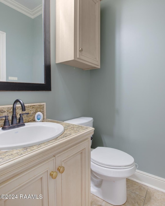 bathroom featuring tile patterned flooring, vanity, toilet, and crown molding