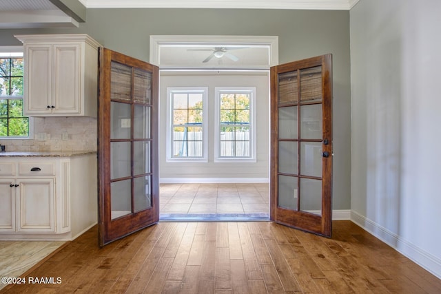 entryway featuring a healthy amount of sunlight, french doors, and light hardwood / wood-style floors