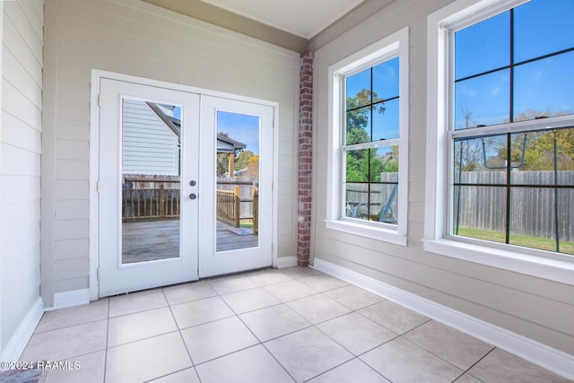 entryway with french doors, light tile patterned floors, and plenty of natural light