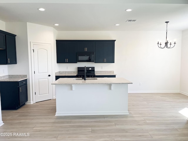 kitchen with light stone counters, wood tiled floor, visible vents, and black appliances