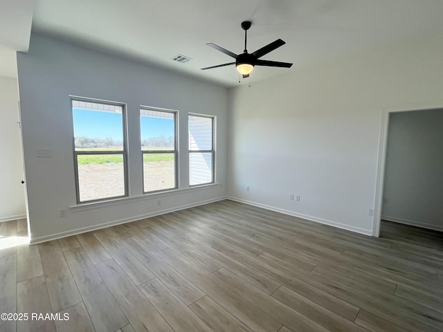 unfurnished room featuring visible vents, ceiling fan, baseboards, and wood finished floors