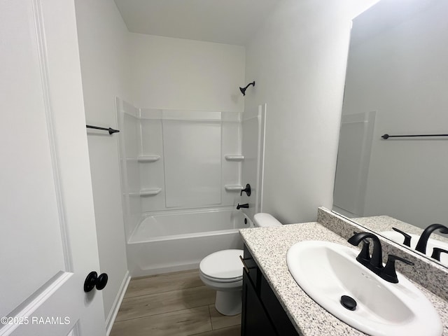 bathroom featuring toilet, shower / washtub combination, wood finished floors, and vanity