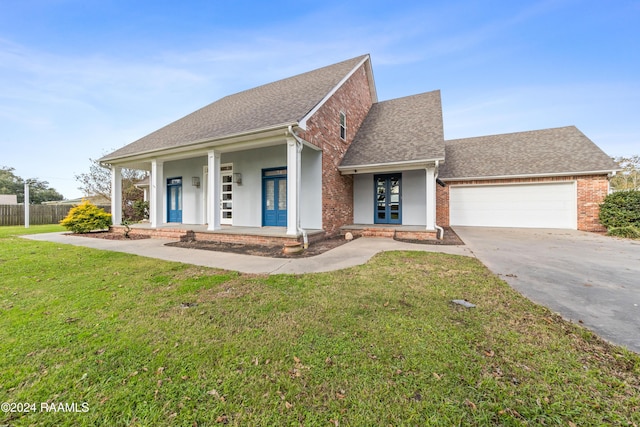 view of front of home with a front yard, a porch, and a garage