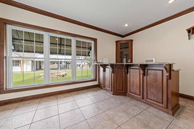 bar featuring light tile patterned floors, plenty of natural light, and crown molding