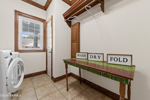 clothes washing area featuring washing machine and dryer, crown molding, and light tile patterned flooring