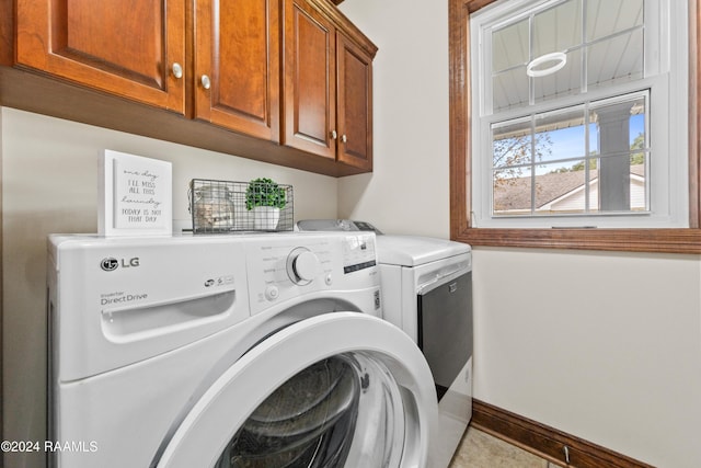 laundry room featuring separate washer and dryer, light tile patterned floors, and cabinets