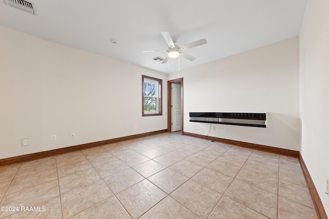 tiled empty room featuring ceiling fan