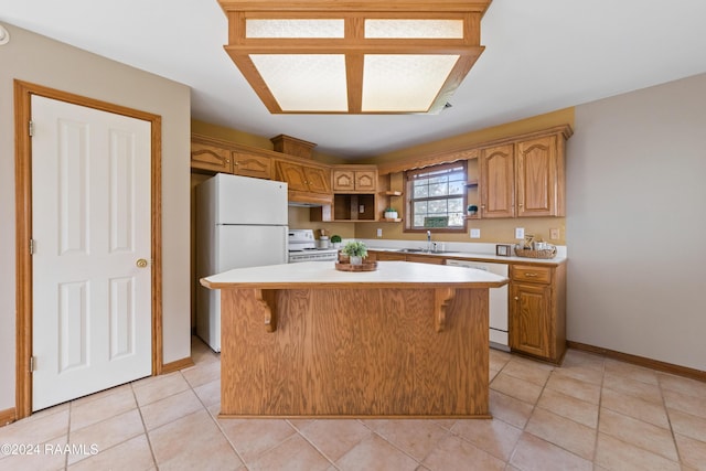 kitchen featuring sink, a kitchen island, white appliances, a breakfast bar area, and light tile patterned floors