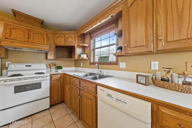 kitchen with light tile patterned floors, white appliances, and sink