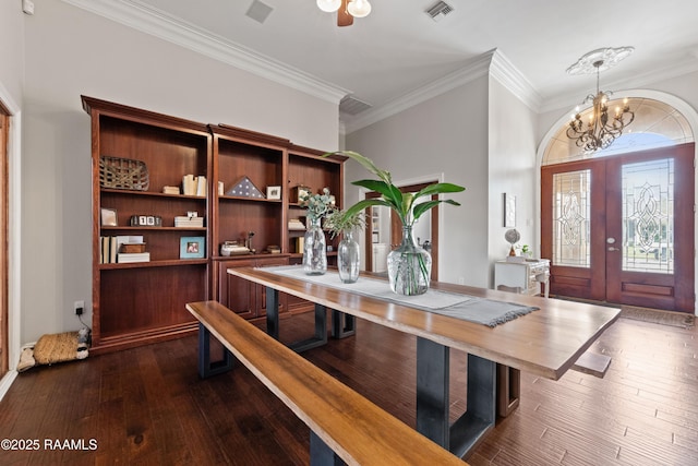 interior space featuring dark wood-type flooring, ornamental molding, french doors, and a chandelier