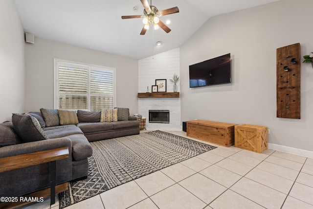 tiled living room featuring lofted ceiling, a large fireplace, and ceiling fan