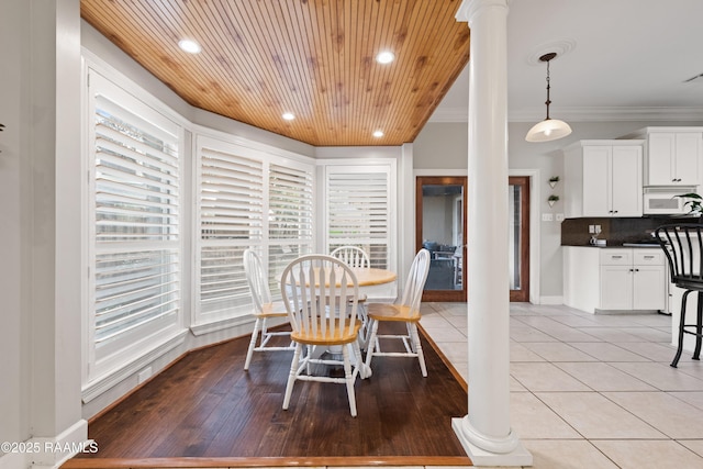 tiled dining room with ornamental molding, decorative columns, and wooden ceiling