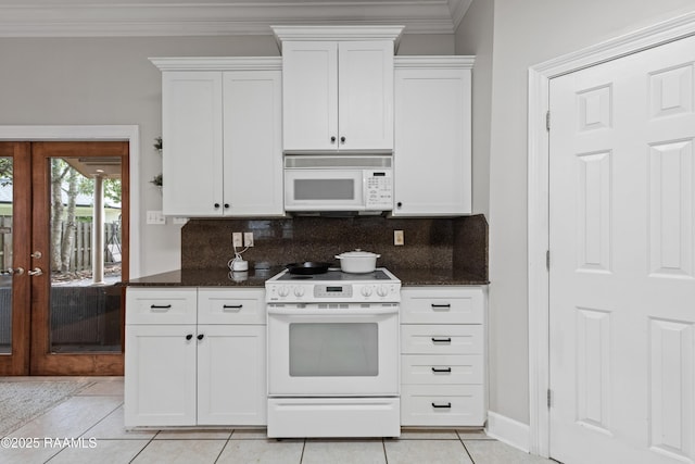 kitchen with white cabinetry, dark stone countertops, backsplash, and white appliances