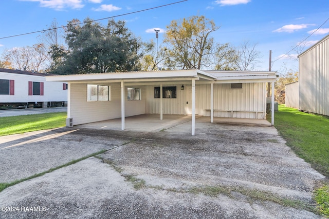 view of front of property featuring a front lawn and a carport