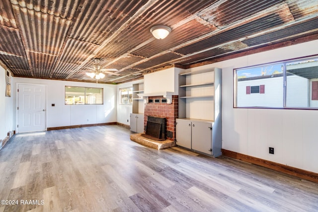 unfurnished living room with a wealth of natural light, ceiling fan, and light hardwood / wood-style floors