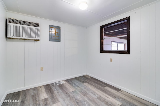 spare room featuring wood walls and wood-type flooring