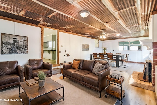 living room featuring ceiling fan, wooden ceiling, a fireplace, and light hardwood / wood-style flooring