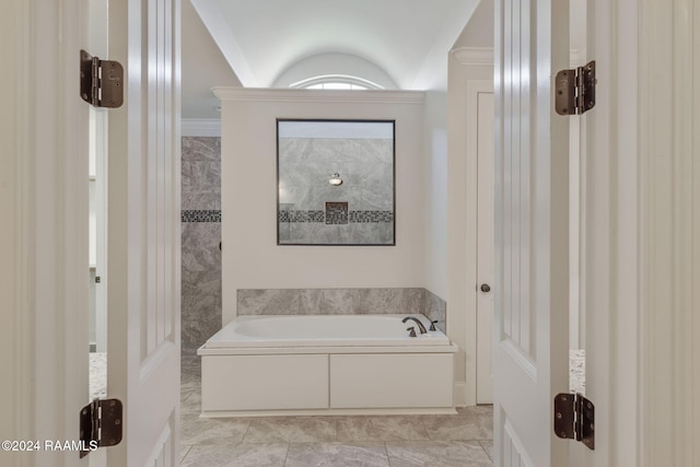 bathroom featuring a tub to relax in, crown molding, and vaulted ceiling