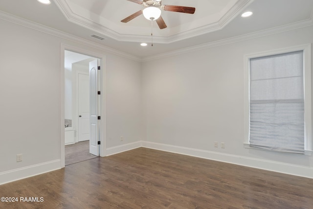 unfurnished room featuring a raised ceiling, ceiling fan, dark hardwood / wood-style flooring, and ornamental molding