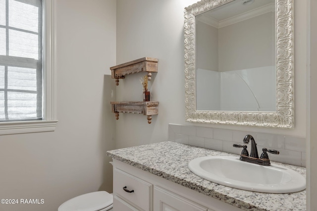 bathroom featuring backsplash, crown molding, a shower, toilet, and vanity