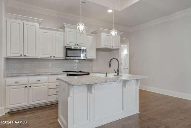 kitchen featuring white cabinets, decorative backsplash, a kitchen island with sink, and hanging light fixtures