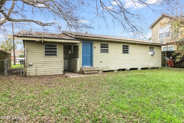 rear view of property featuring a lawn