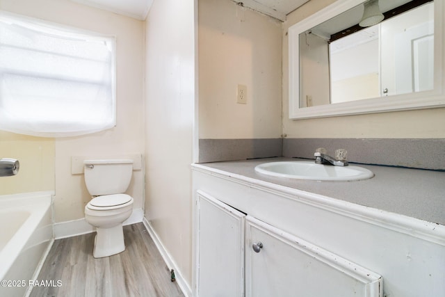 bathroom with a washtub, hardwood / wood-style flooring, toilet, and sink