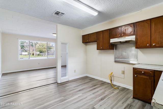 kitchen featuring light wood-type flooring and a textured ceiling