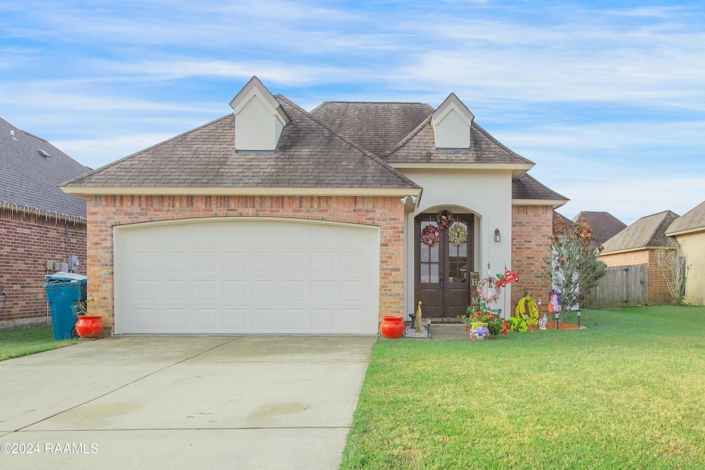 view of front of house with a garage and a front lawn