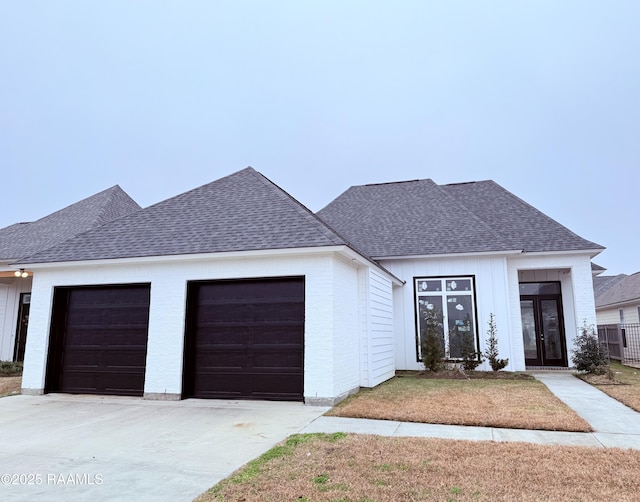 view of front of house with a garage, a front lawn, and french doors