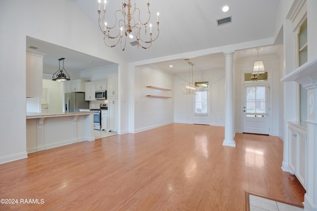 unfurnished living room featuring light hardwood / wood-style floors, ornate columns, ornamental molding, and a high ceiling