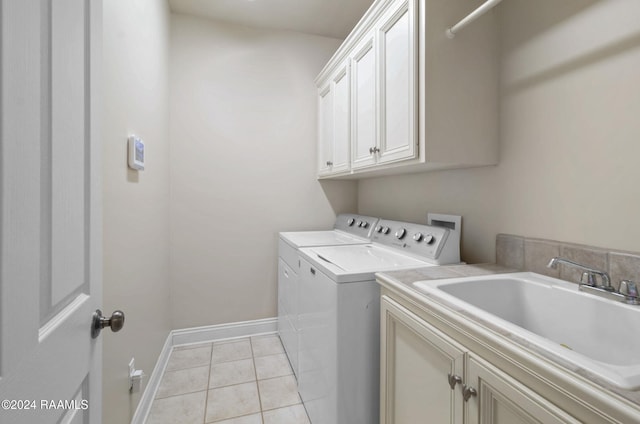 washroom with washing machine and clothes dryer, sink, light tile patterned flooring, and cabinets