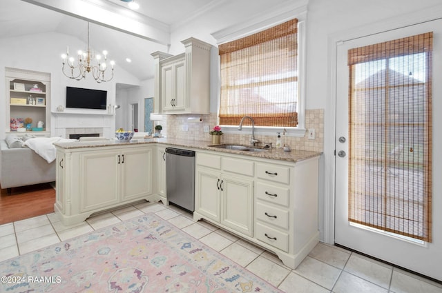 kitchen with pendant lighting, dishwasher, sink, light tile patterned floors, and a fireplace