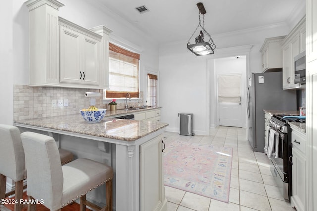 kitchen with a kitchen breakfast bar, high end stainless steel range oven, decorative light fixtures, light tile patterned flooring, and light stone counters